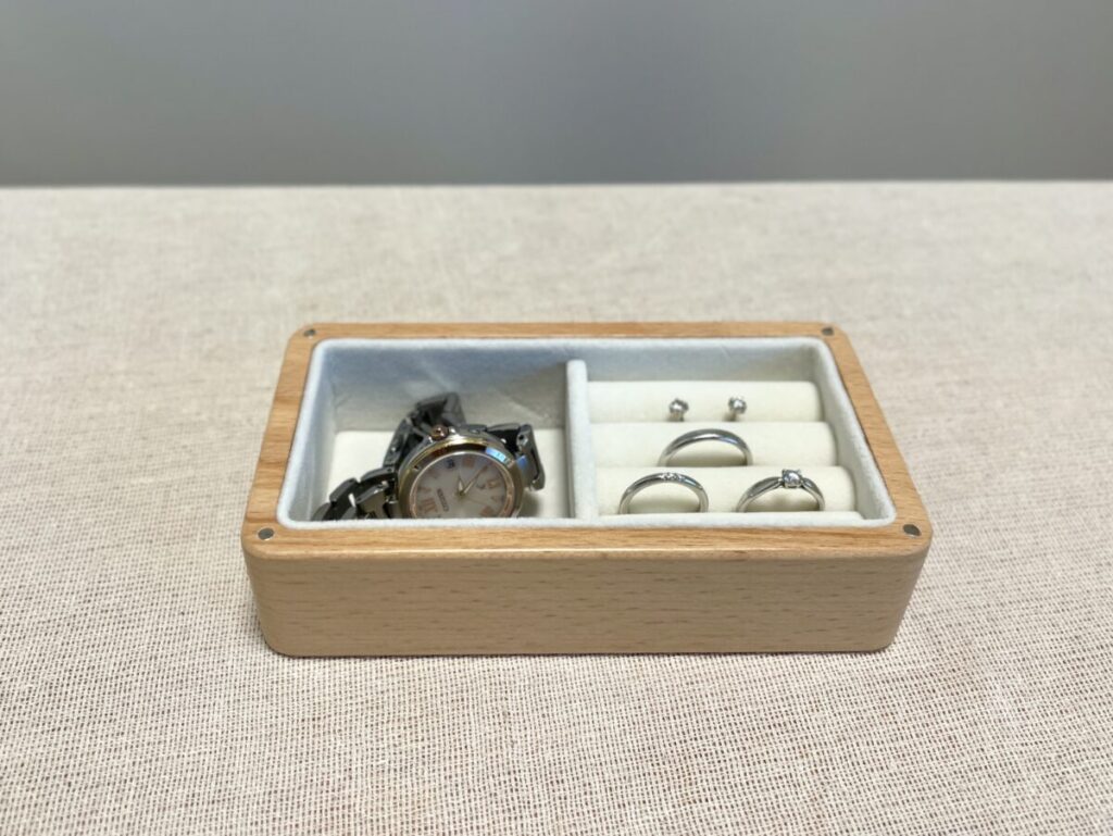 木のジュエリーボックスに入った時計や指輪など